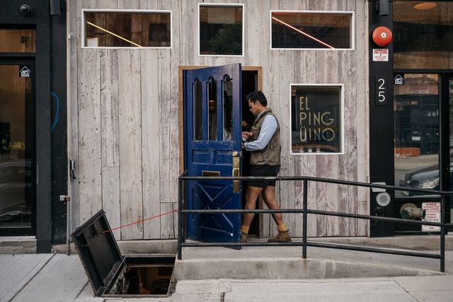 The blue front door of El Pinguino, an oyster bar, is steps away from the Greenpoint waterfront studded with luxury towers in the flood zone.